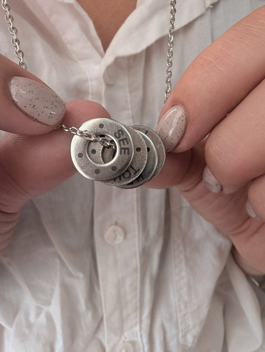 Necklaces shown in brass and stainless steel. Pendant has 5 senses grounding technique printed on it.
